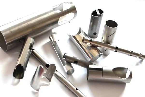 Multiple stainless steel tube parts with laser-cut holes and slots