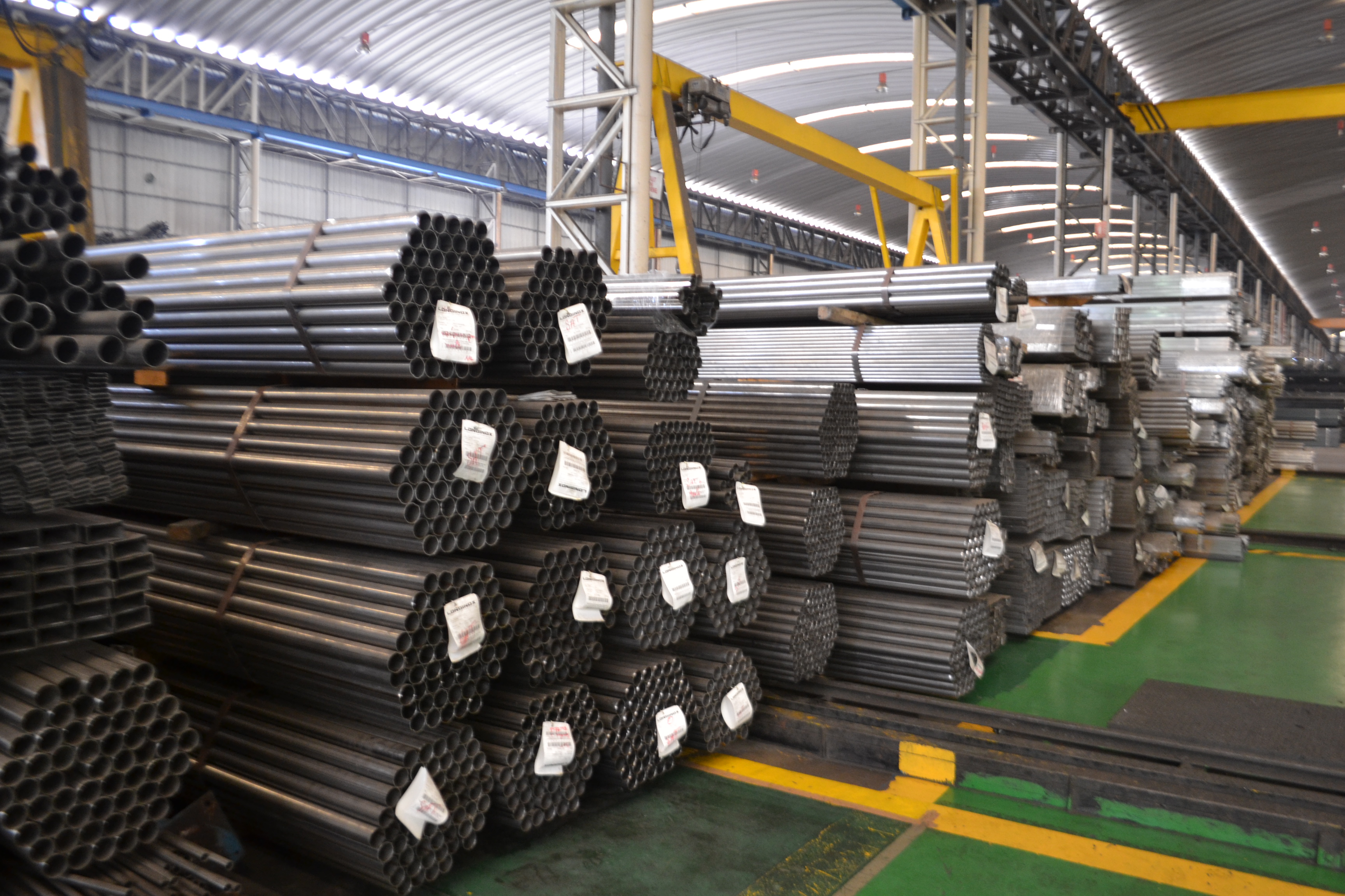 Bundled stainless steel tubes stored on supports in a warehouse
